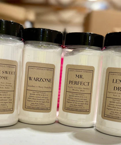 Assorted scented carpet powder jars lined up on a shelf from Simply Serenity carpet freshener collection